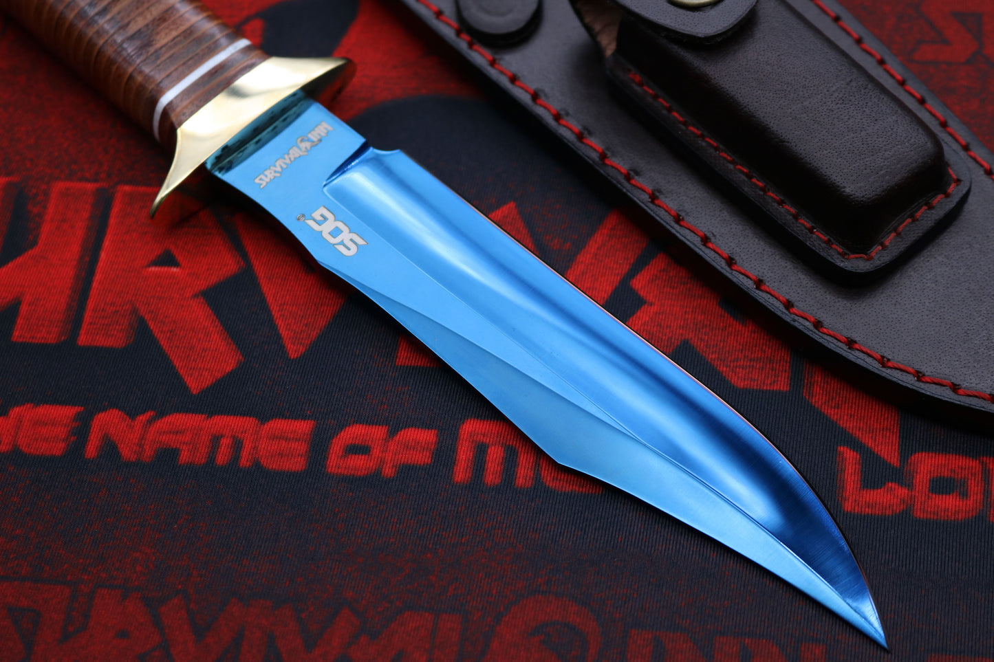 Blued blade Cold Steel Bowie knife placed on forest log with sheath, outdoor survival scene