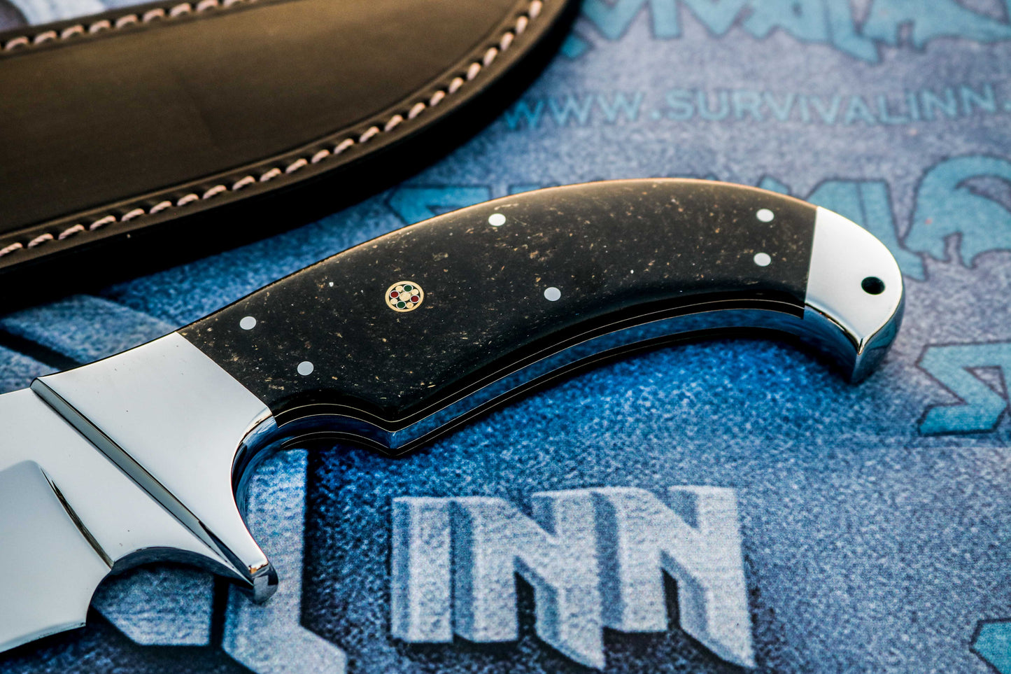 Galaxy micarta handle on handmade Bowie knife showing deep blue and cosmic swirl pattern
