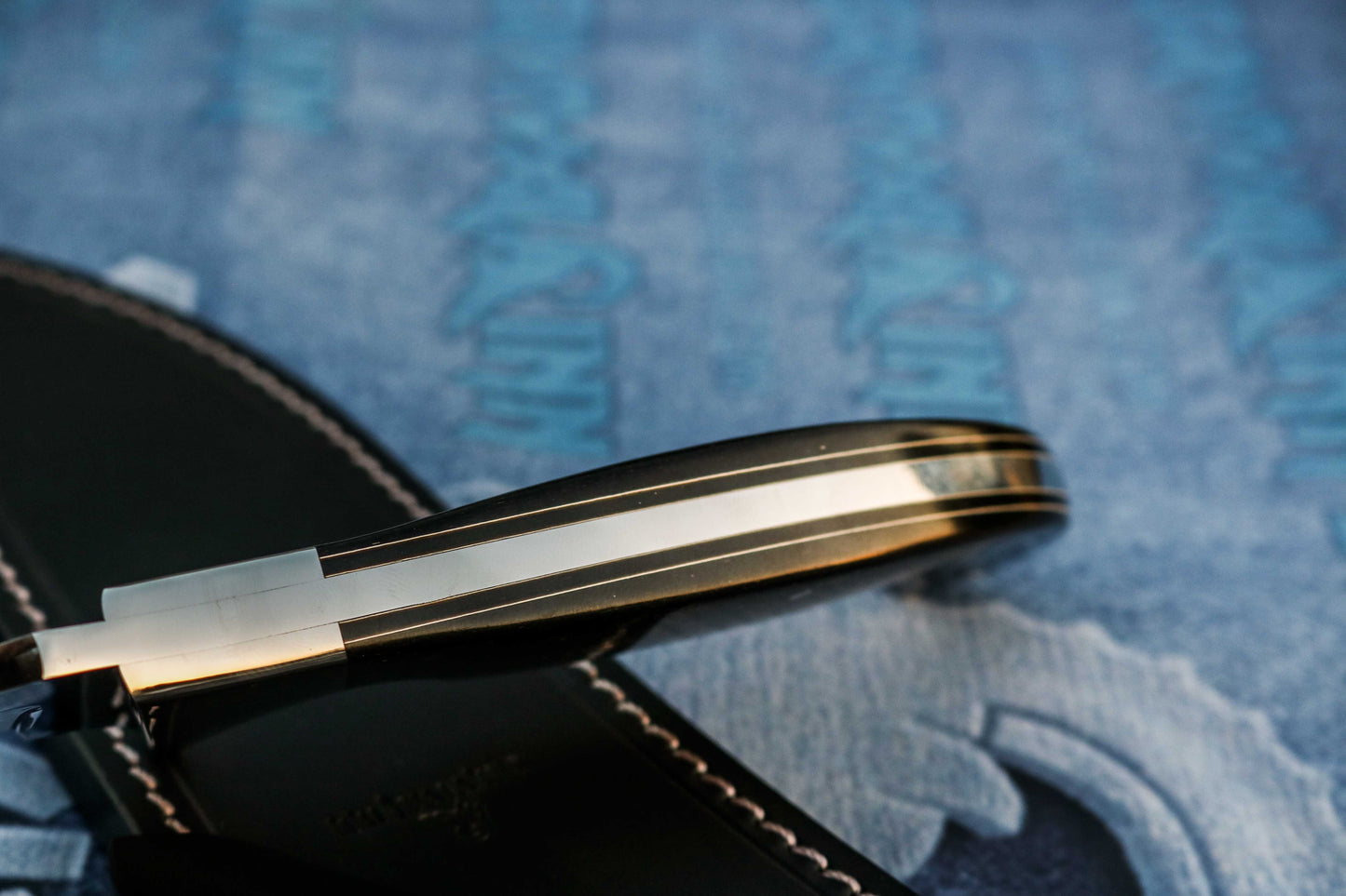 Galaxy micarta handle on handmade Bowie knife showing deep blue and cosmic swirl pattern
